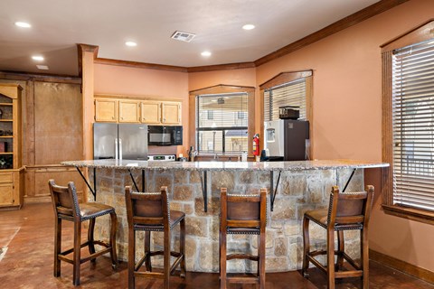 a kitchen with a bar and chairs