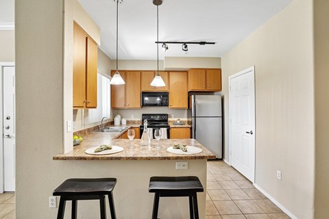 A kitchen with a table and two stools.