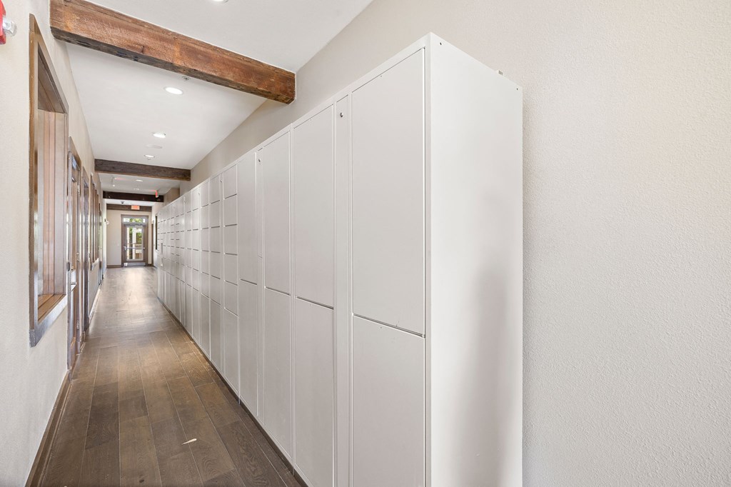 a long row of white cabinets in a hallway with wood floors at Lakeline East Apartments, Cedar Park, 78613