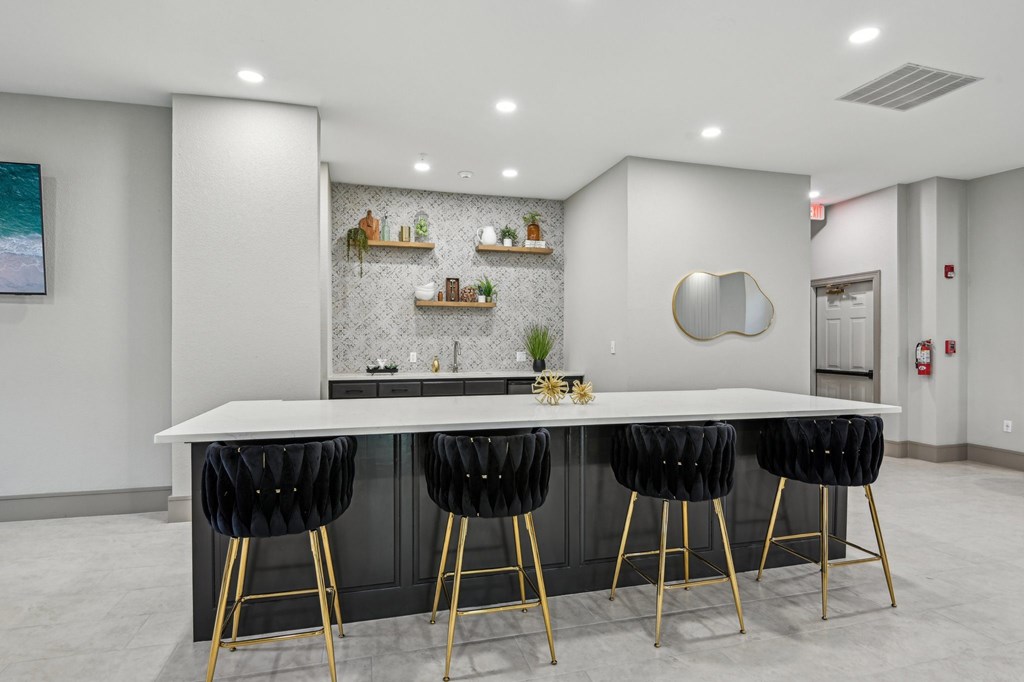 A modern kitchen with a white countertop and black bar stools.