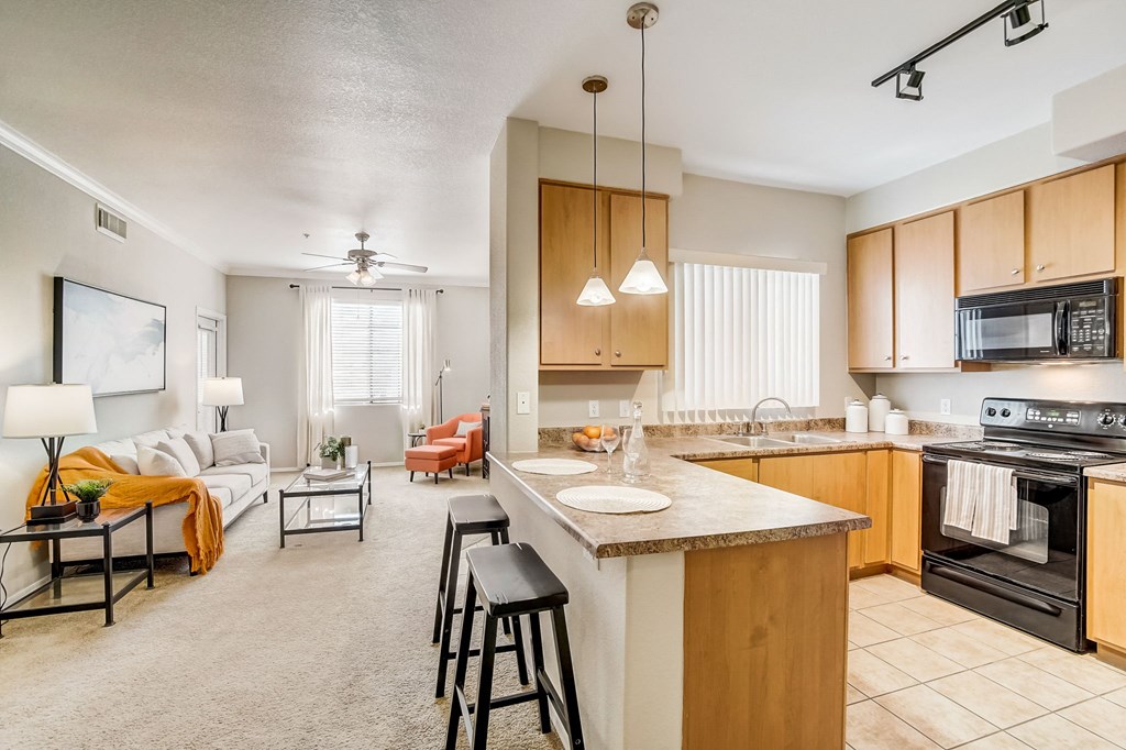 an open kitchen and living room with a large counter top  at Adiamo Palm Valley, Goodyear, Arizona