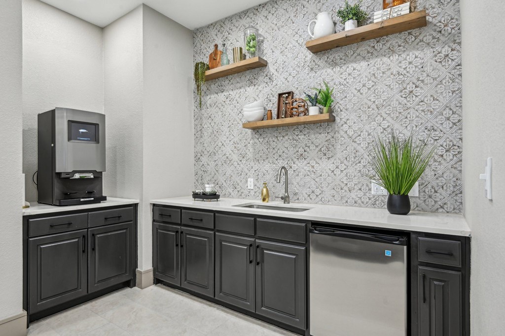 A kitchen with black cabinets and a stainless steel dishwasher.