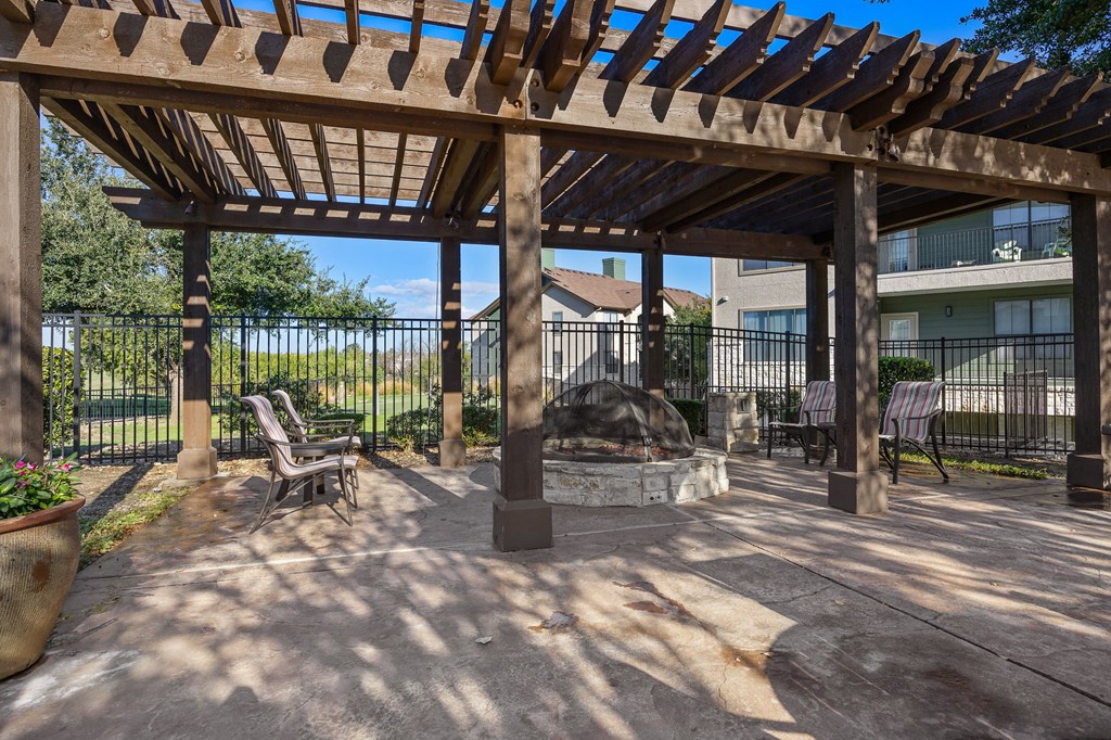 a patio with a fire pit and a pergola at The Fairways at Star Ranch, Hutto, Texas