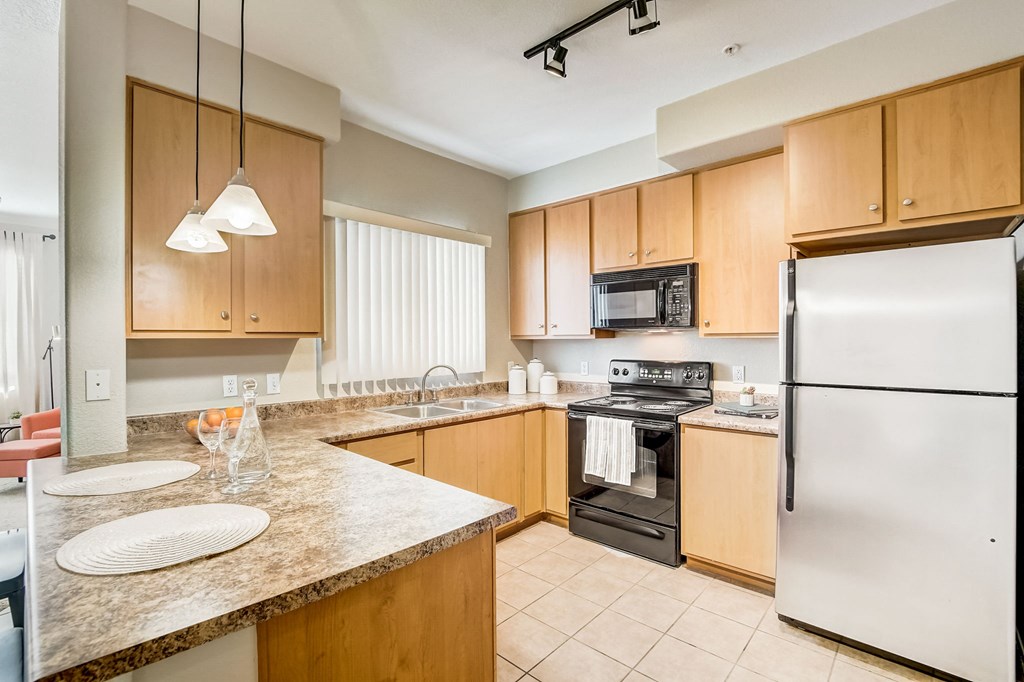 full kitchen with granite counter tops and stainless steel appliances  at Adiamo Palm Valley, Goodyear