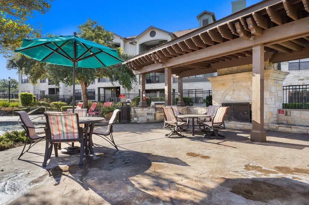 a patio with tables and chairs and umbrellas at The Fairways at Star Ranch, Hutto, Texas