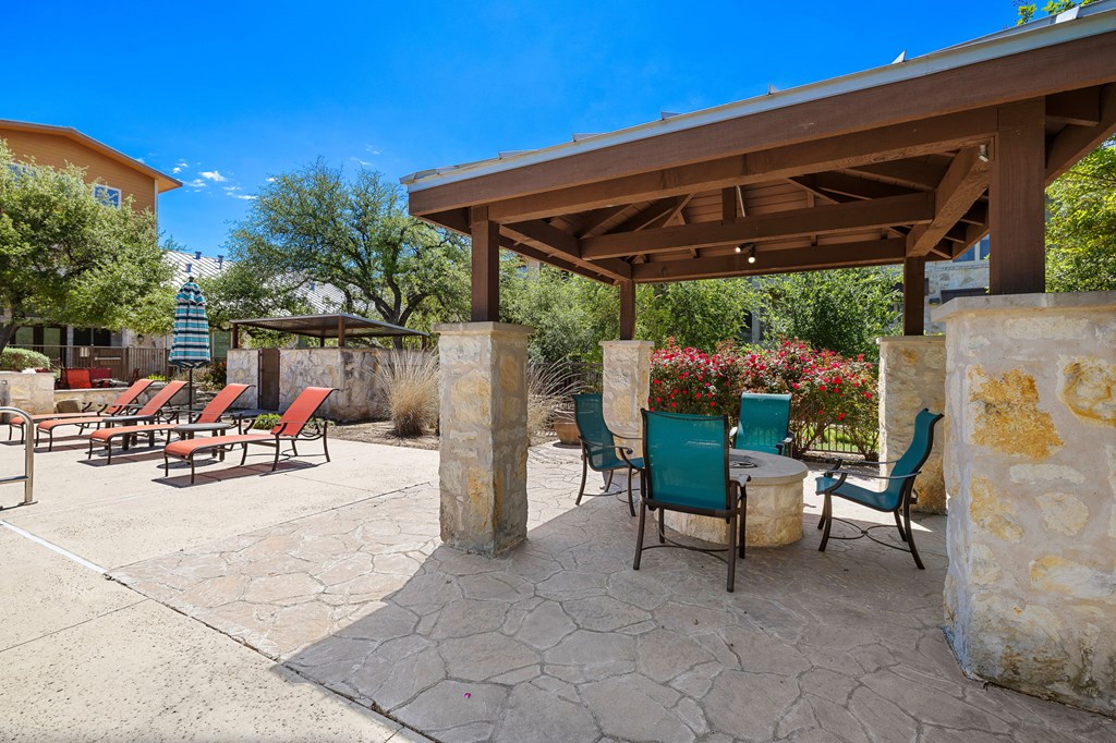 a patio with a table and chairs under a pavilion at Lakeline East Apartments, Cedar Park