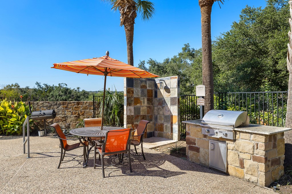 a patio with a table and chairs and a grill at The Verandah, Austin, TX, 78726