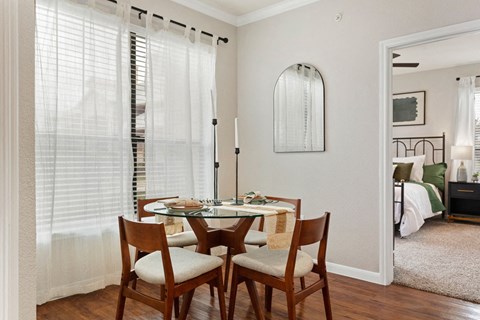 Dining area with round glass table and mirror at The Fairways at Star Ranch Apartments, Hutto, Texas