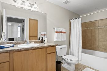 A bathroom with a white toilet, sink, and bathtub. at Adiamo Palm Valley, Goodyear, AZ, 85395