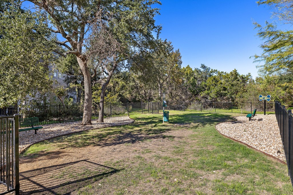 a dog park with trees and a fence at Sonterra Apartment Homes, Austin, TX
