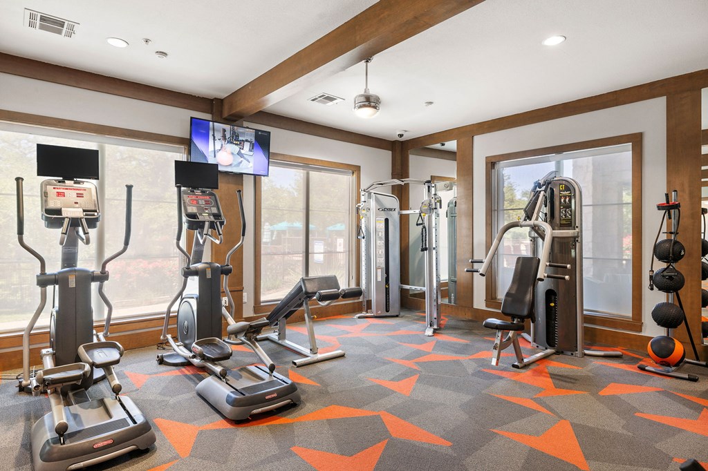 a home gym with exercise equipment and windows at Lakeline East Apartments, Cedar Park, 78613