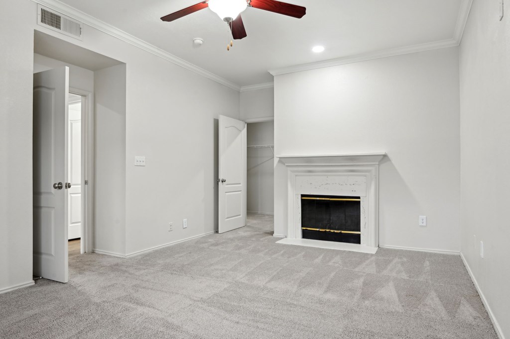 A room with a fireplace and a ceiling fan.
