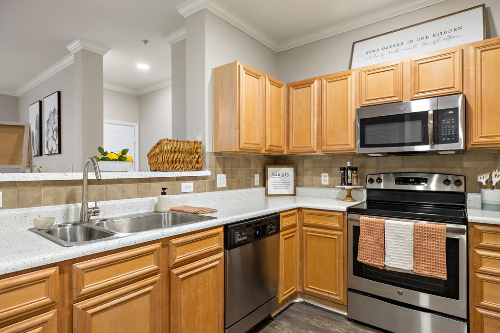 a kitchen with wooden cabinets and stainless steel appliances at The Verandah, Austin, 78726