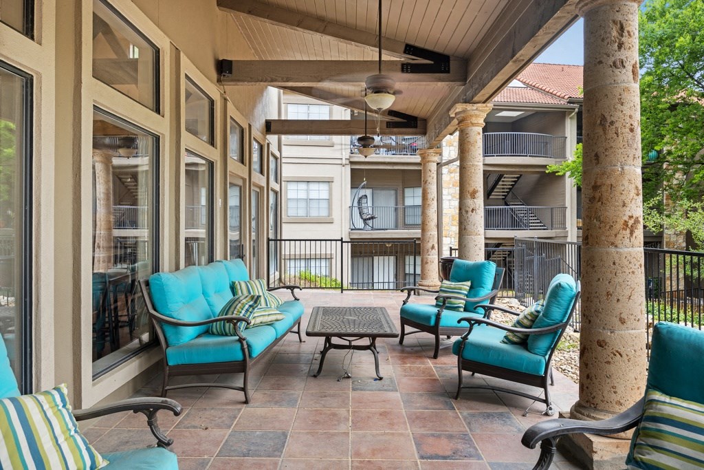 a covered patio with blue chairs and a coffee table at Waters Edge Apartment Homes, Georgetown