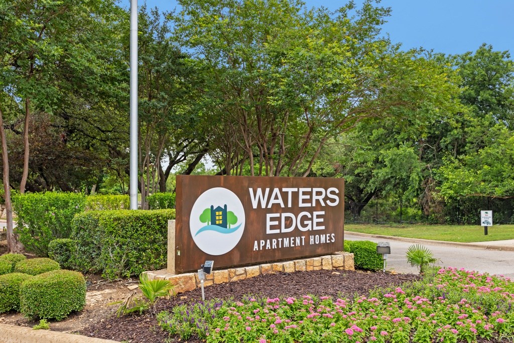 a sign that says waters edge apartments with trees in the background at Waters Edge Apartment Homes, Georgetown, Texas