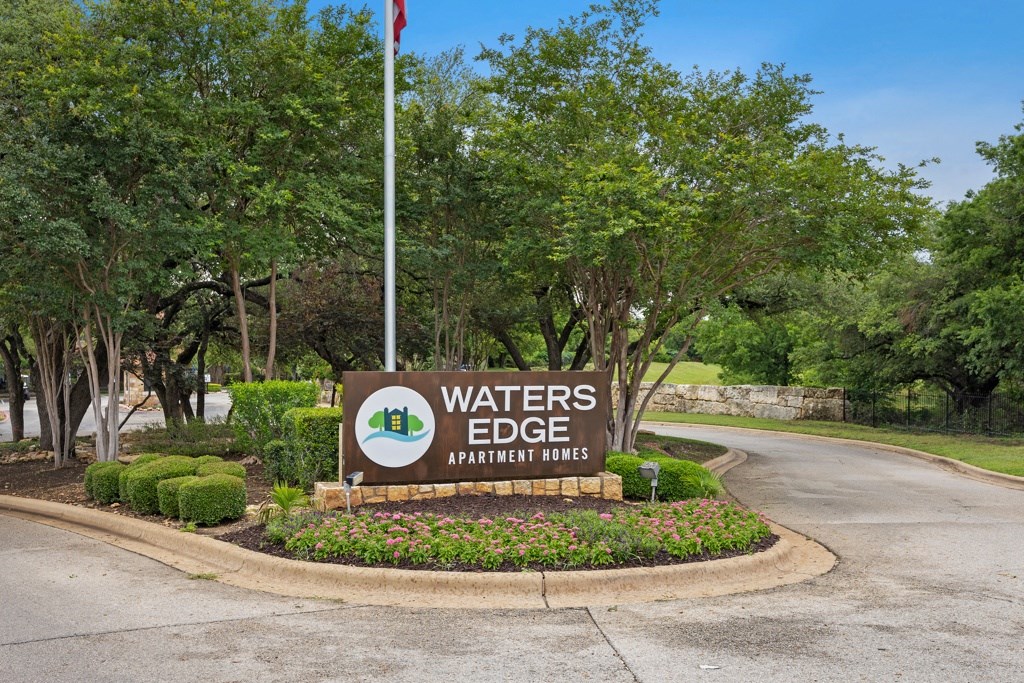 a sign that says waters edge apartments with trees in the background at Waters Edge Apartment Homes, Georgetown, TX