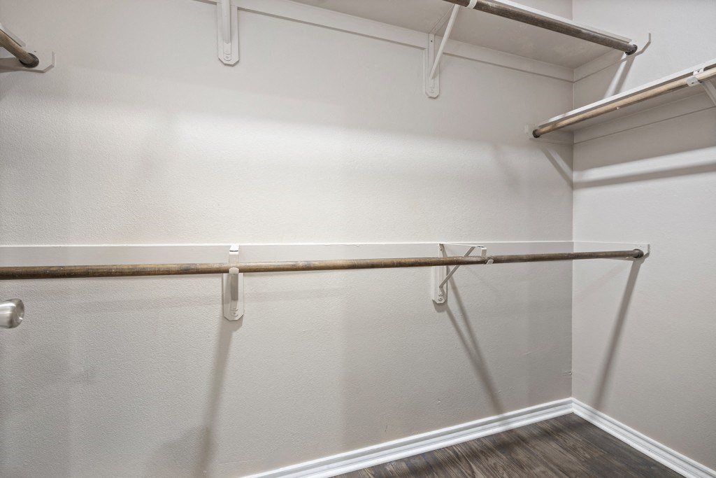 a spacious walk in closet in a bedroom with white walls at Waters Edge Apartment Homes, Georgetown, Texas