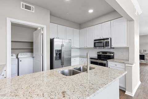 a kitchen with white cabinets and a counter top