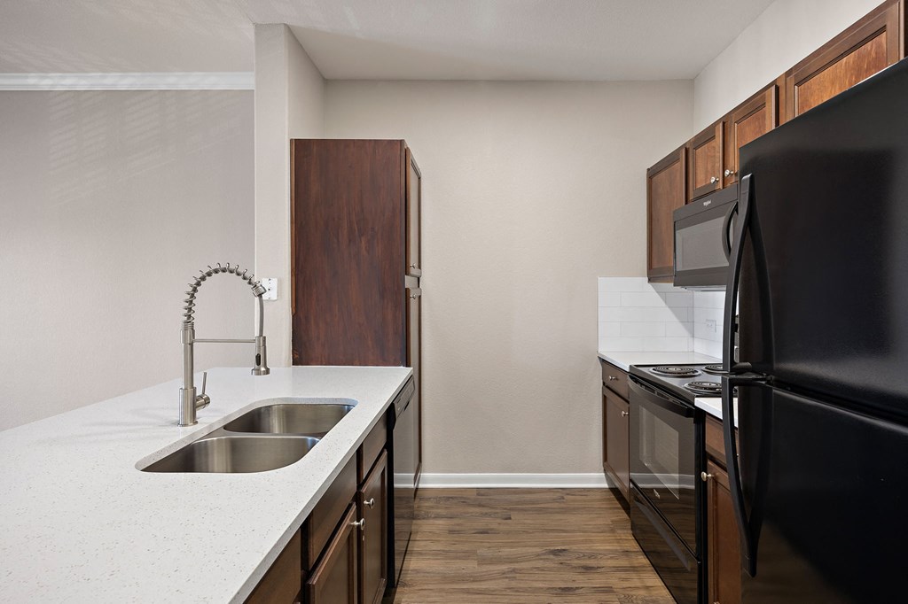an empty kitchen with black appliances and a white counter top at The Fairways at Star Ranch, Texas