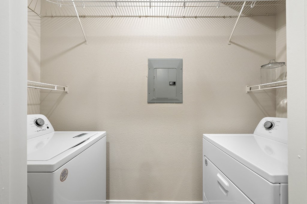 a white laundry room with two washes and a dryer at The Verandah, Texas