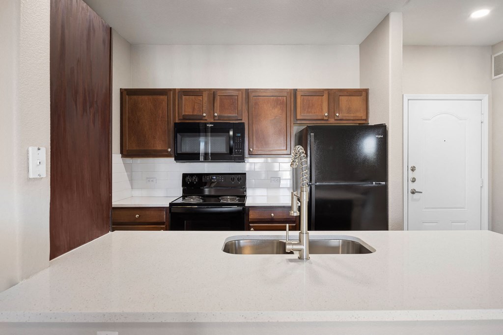 a kitchen with a white counter top and a black refrigerator at The Fairways at Star Ranch, Hutto, Texas