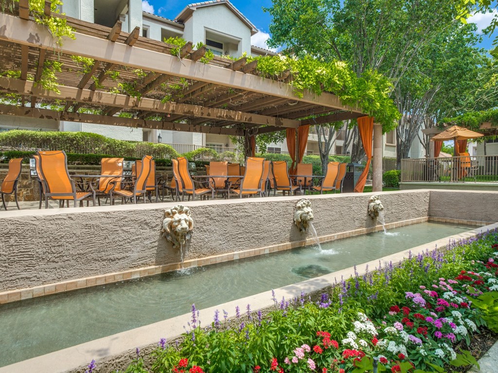 a swimming pool with chairs and water fountains at La Ventura Apartments, Plano, 75093