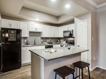 a kitchen with white cabinets and a counter top at La Ventura Apartments, Plano, Texas, 75093