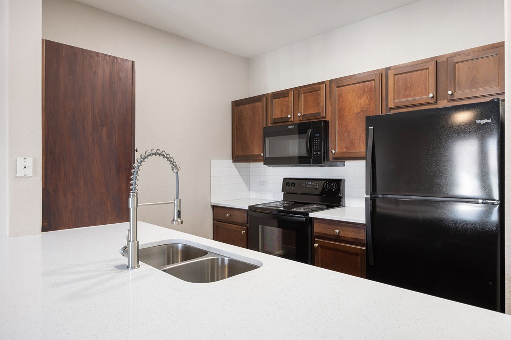 a kitchen with black appliances and white counter tops at The Fairways at Star Ranch, Hutto