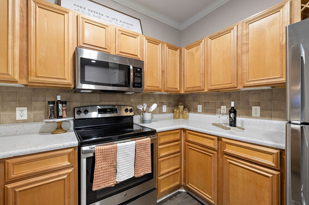 a kitchen with stainless steel appliances and wooden cabinets at The Verandah, Texas, 78726