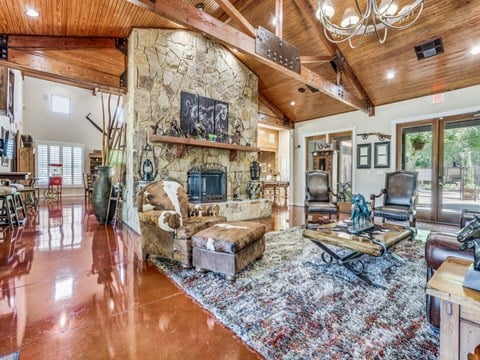the living room has a large stone fireplace and a large rug