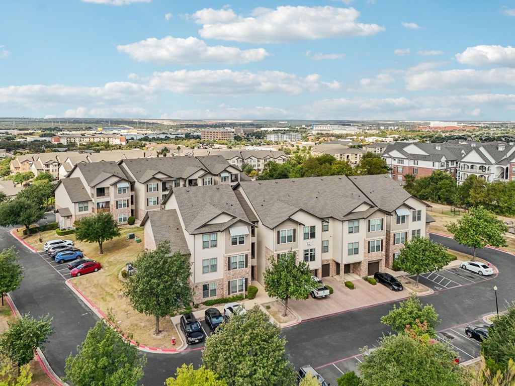 A large apartment complex with a parking lot in front.