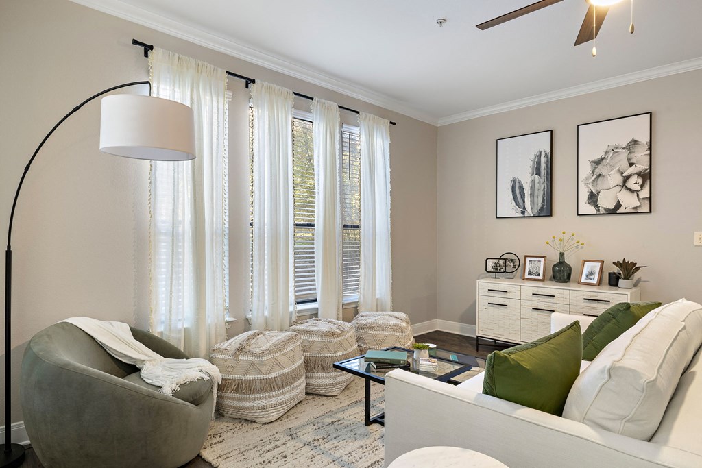 a living room with white curtains and a couch and a table at The Verandah, Texas, 78726