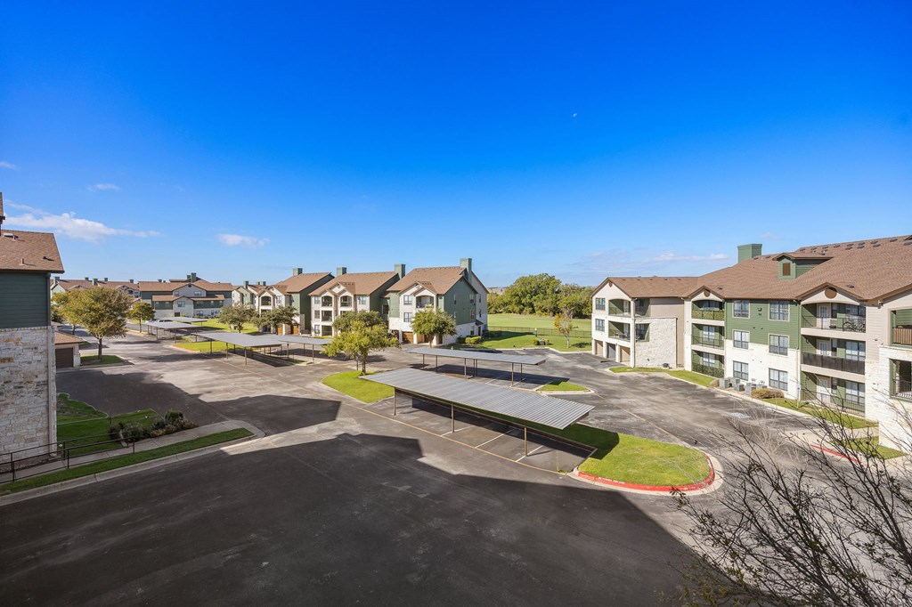 an aerial view of an empty parking lot with houses in the background at The Fairways at Star Ranch, Hutto, TX, 78634