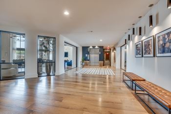 A long hallway with a bench and pictures on the wall. at Aurora Watson Branch, Mansfield, 76063
