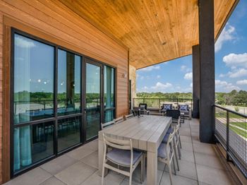 a large deck with a table and chairs and sliding glass doors at Aurora Watson Branch, Mansfield, Texas