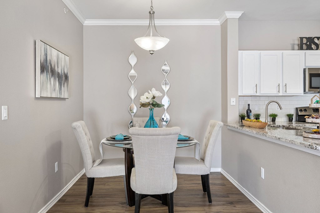a dining room with a table and chairs and a kitchen at Sonterra Apartment Homes, Austin, 78726