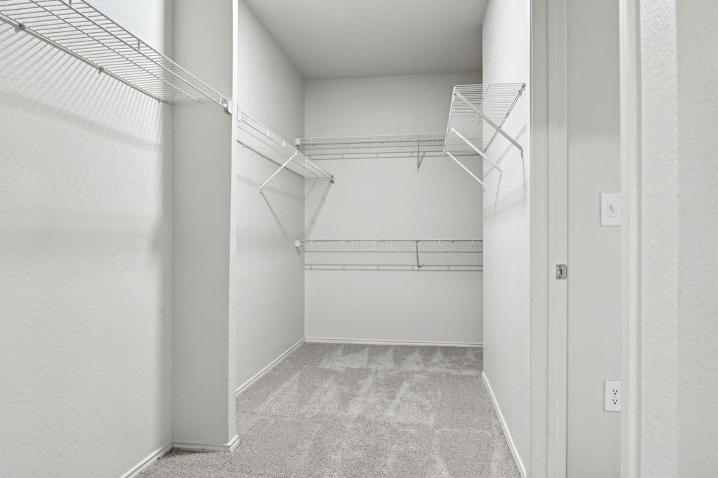 A white hallway with a carpeted floor and a door on the right.