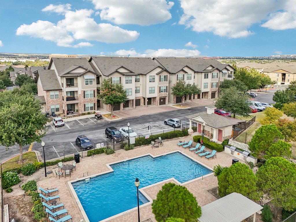 A large apartment complex with a pool in the foreground.