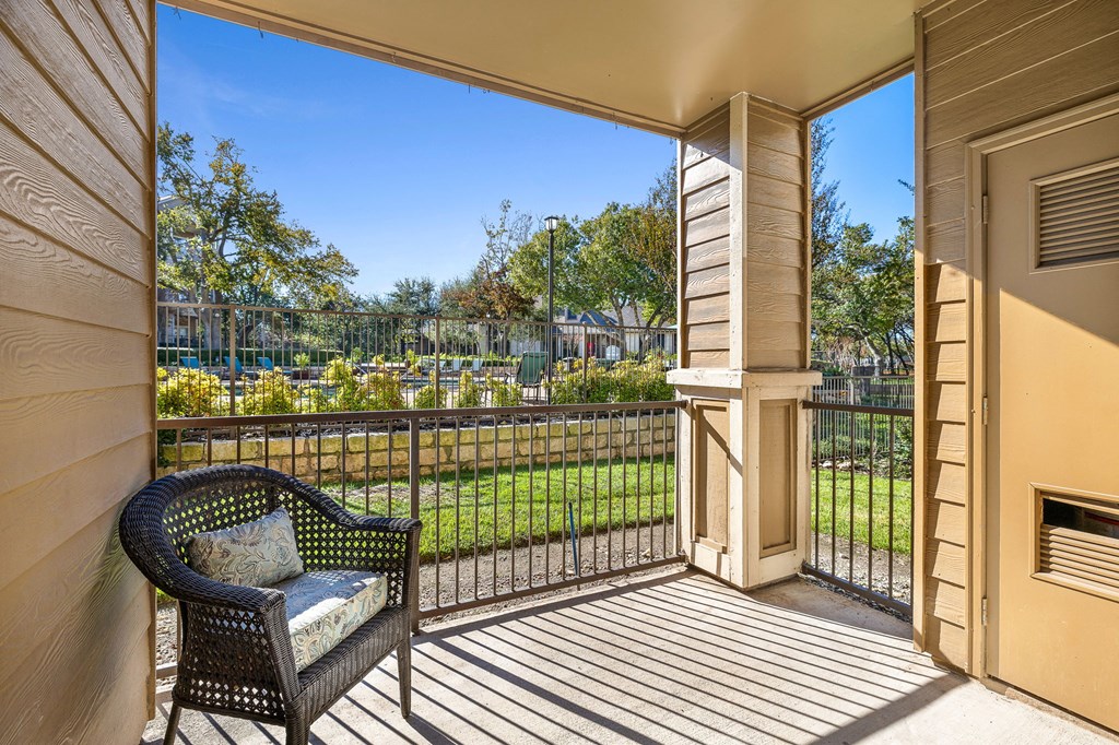 a balcony with a chair and a fence and a garden at Sonterra Apartment Homes, Austin, 78726
