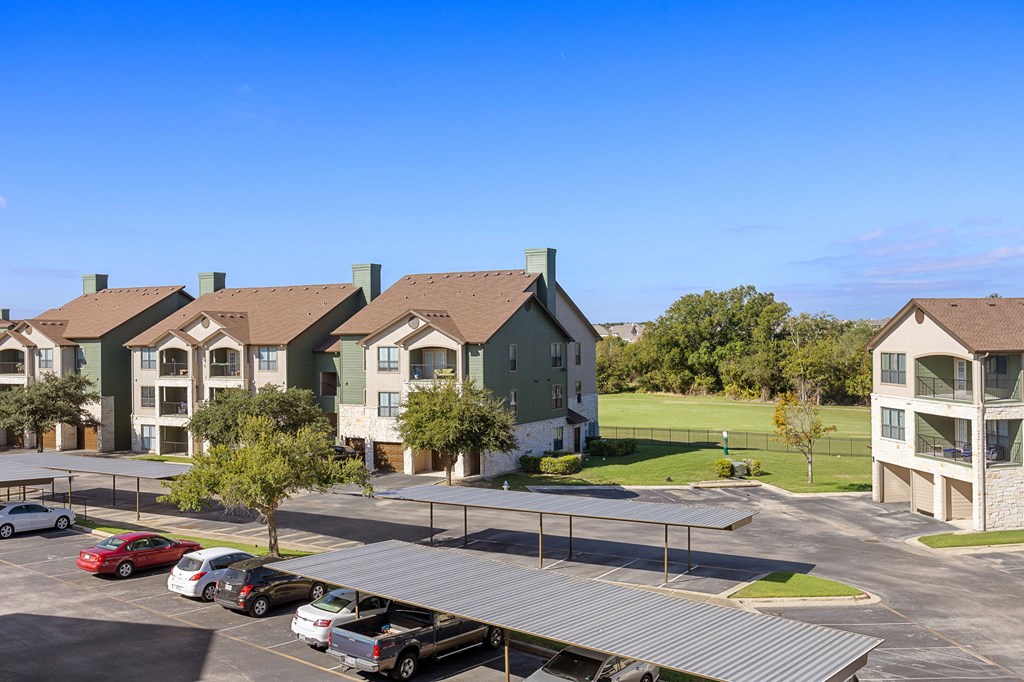 an aerial view of an apartment complex with a parking lot at The Fairways at Star Ranch, Hutto, Texas