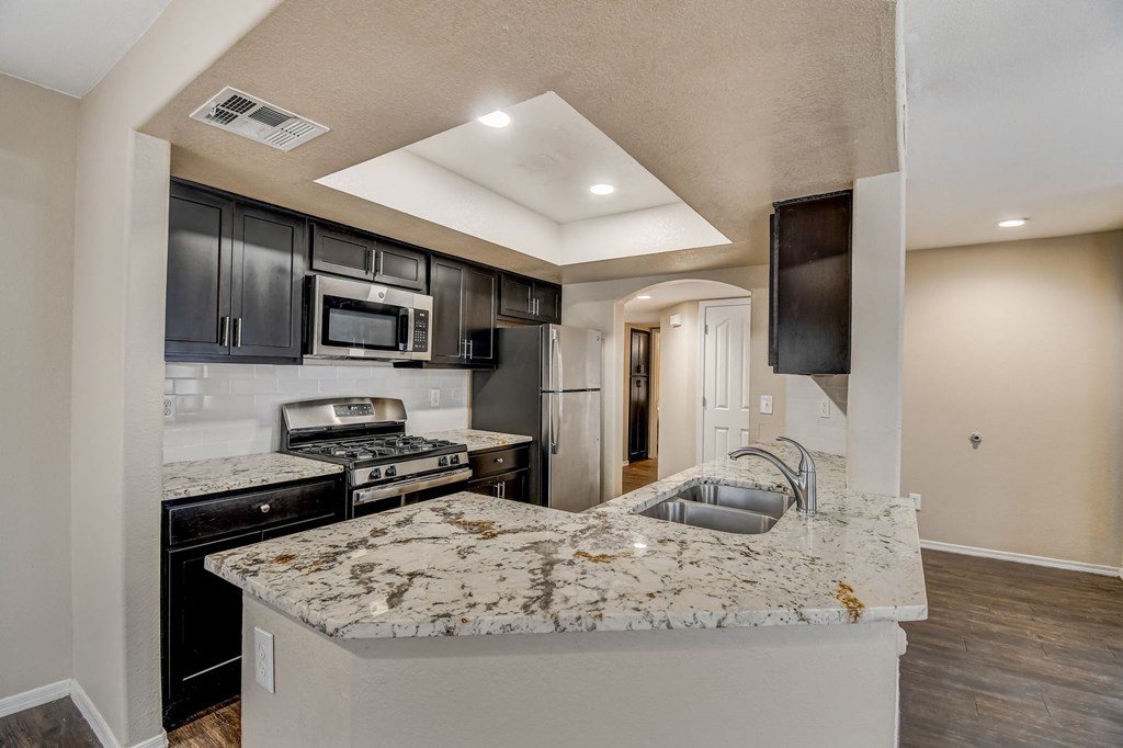 an open kitchen with granite counter tops and black cabinets  at San Montego Apartments, Mesa, 85206