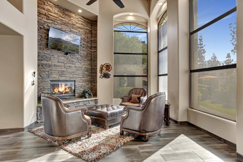 a living room with two leather chairs and a fireplace