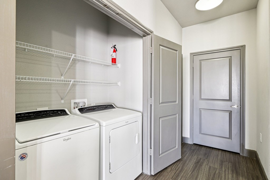 A laundry room with a washer and dryer and a door.