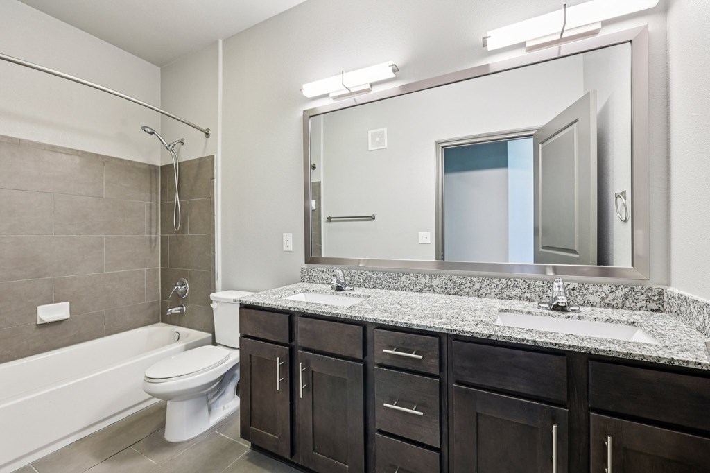 A bathroom with a white toilet and a white bathtub.