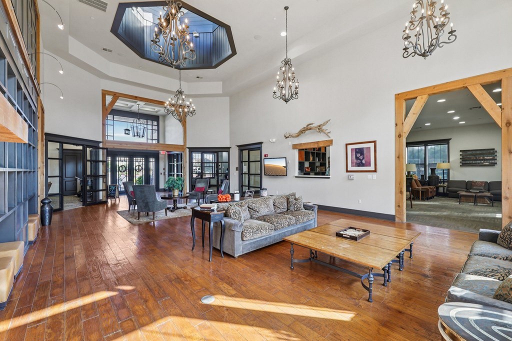 A living room with a wooden floor and a large chandelier.