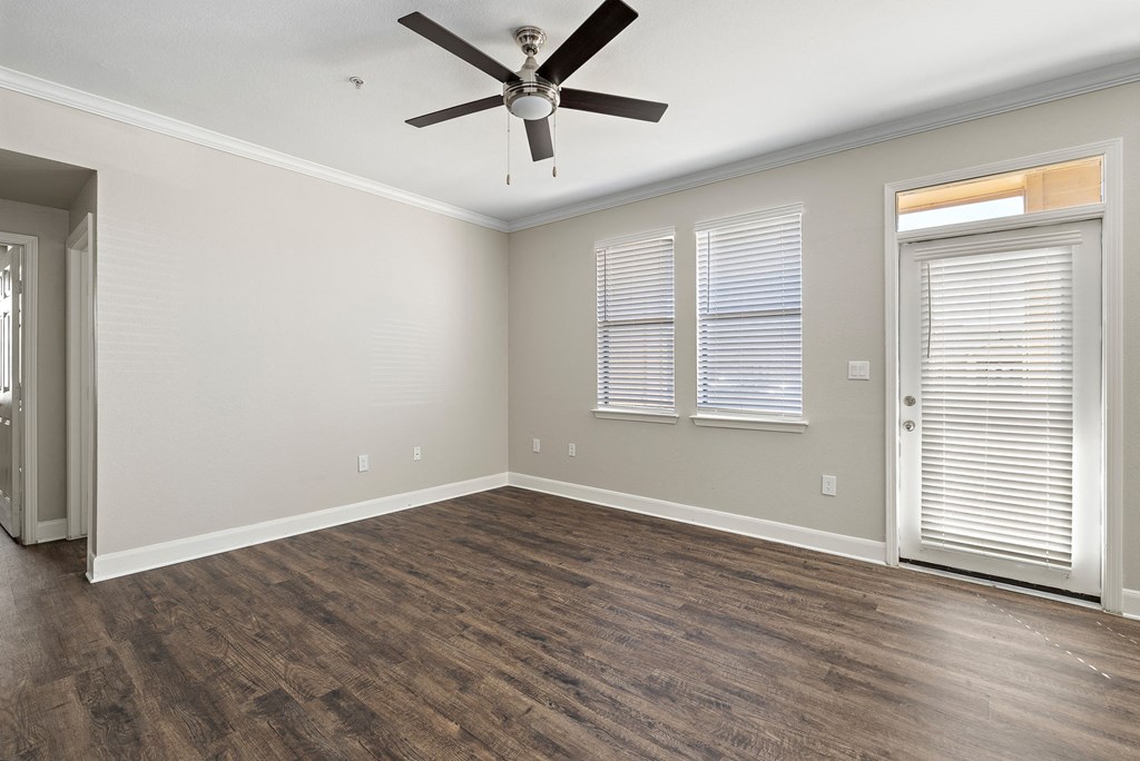 an empty living room with a ceiling fan and window at The Verandah, Texas