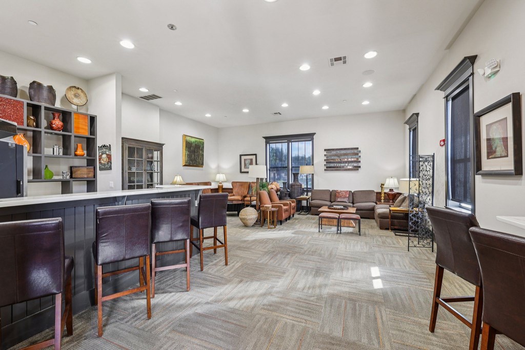 A living room with brown leather chairs and a grey carpet.