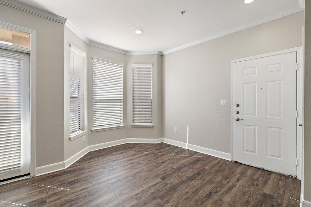 an empty living room with a white door and windows at The Verandah, Austin, TX, 78726