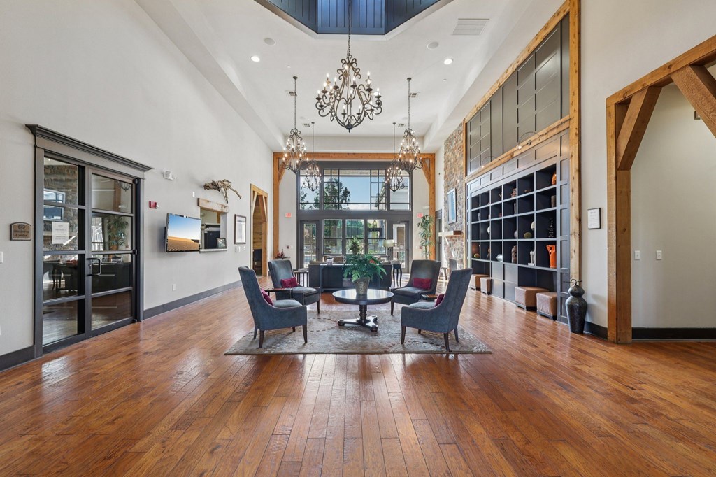 A large room with a wooden floor and a chandelier hanging from the ceiling.