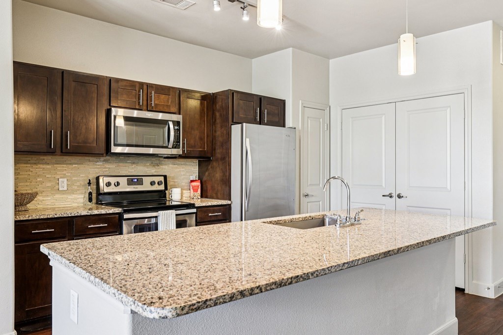 A kitchen with a granite countertop and white cabinets.